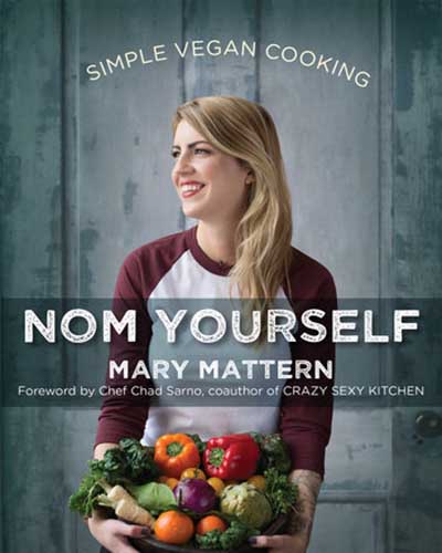 A cover for the book Nom Yourself. Features a picture of the author, a woman, holding a bowl of fresh vegetables and fruit with a grey background.