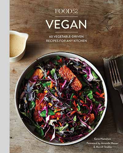 The cover of the book Food52 Vegan. Features a bowl of colorful vegan food sitting on top of a wooden table.