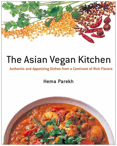 Cover for the book The Asian Vegan Kitchen. Features a bowl of curry lentils at the bottom and fresh and dried herbs and beans at the top. All on a white background.