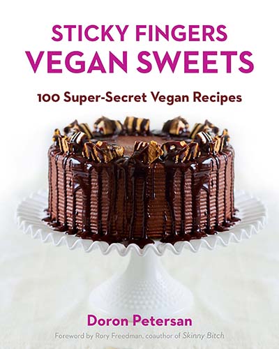 Cover for the book Sticky Fingers Vegan Sweets, features a picture of a multi-layer chocolate cake sitting on a white cake stand.