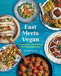 Cover of the book, East Meets Vegan. Features seven different colorful plant-based meals sitting on a blue table.