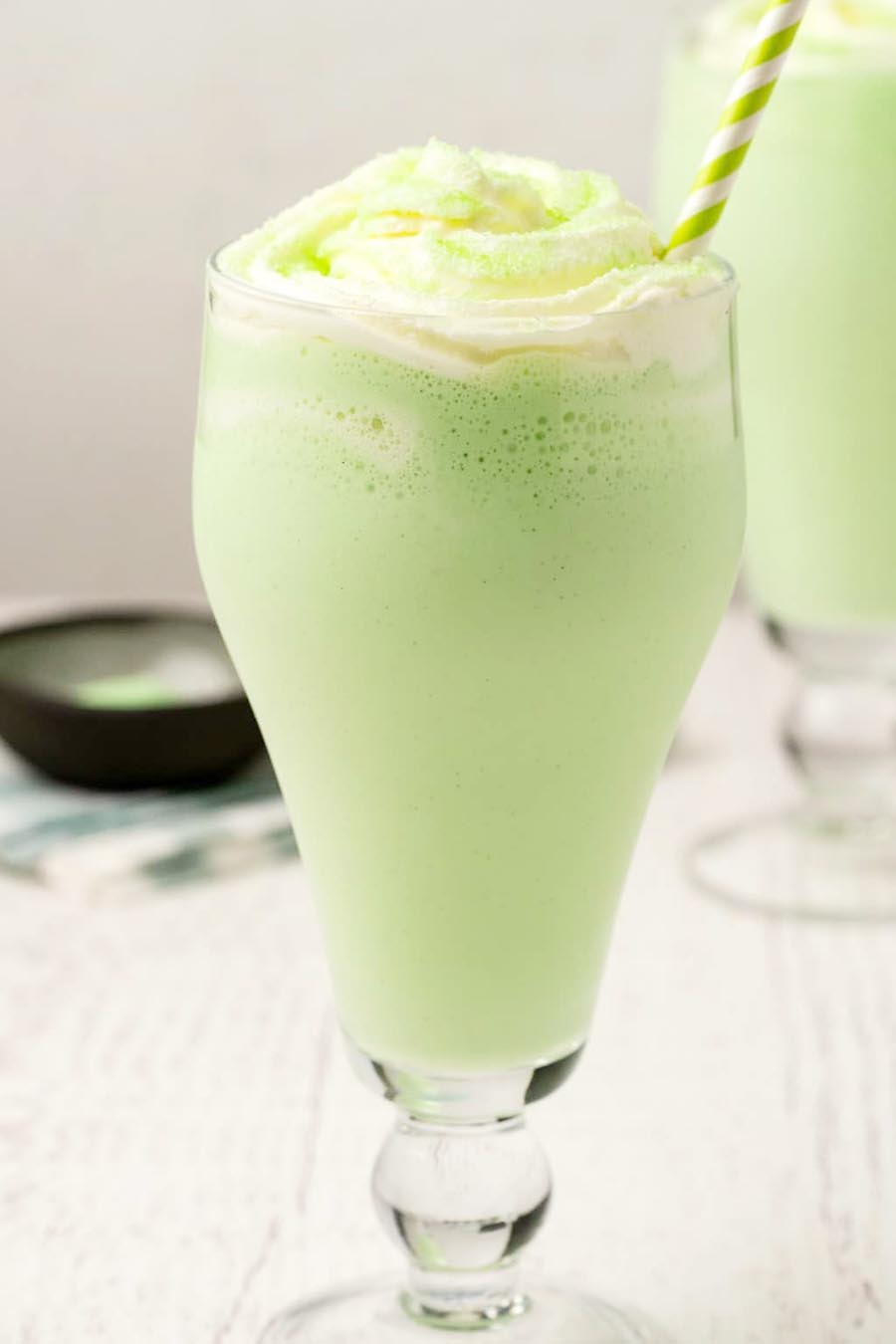 Two shamrock shakes in glasses with striped straws