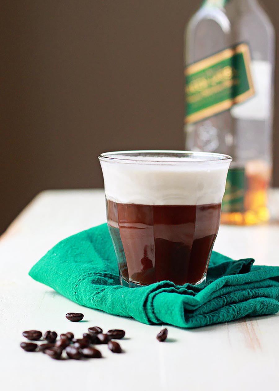 Glass of Irish coffee sitting on a tea towel