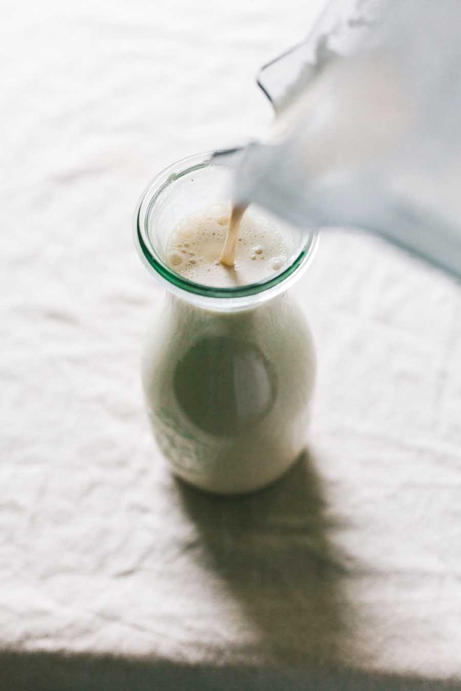Pouring creamer into a glass jar.